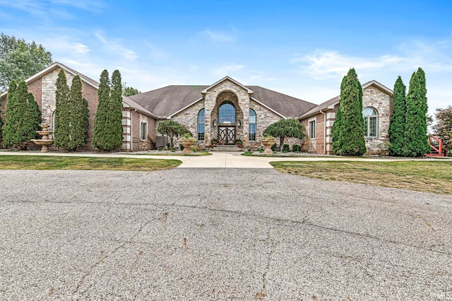 view of front of house with central AC unit and a front lawn