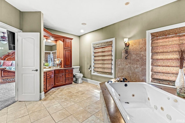 bathroom with tile patterned flooring, tiled bath, toilet, and vanity