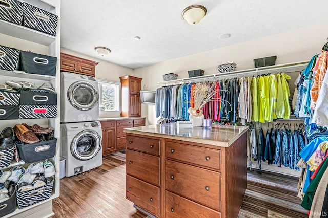 interior space with dark wood-type flooring and stacked washing maching and dryer