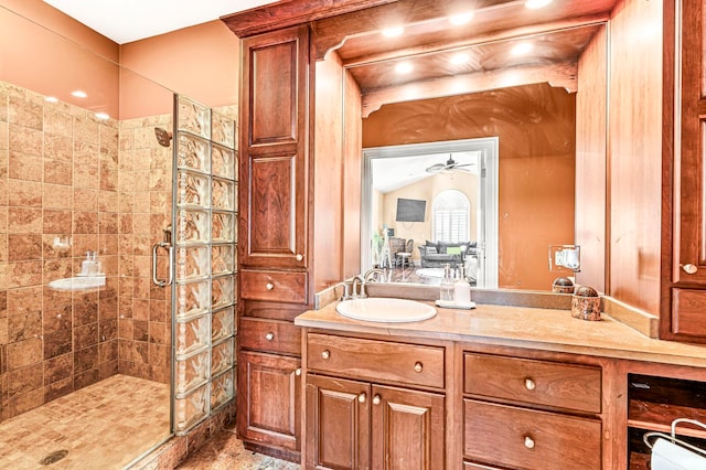 bathroom featuring ceiling fan, a shower with door, and vanity