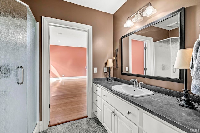 bathroom with a shower with shower door and vanity