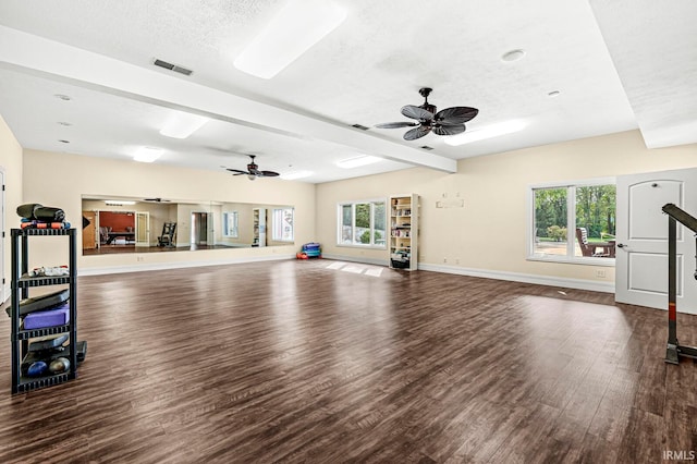 workout room with dark wood-type flooring, ceiling fan, and a textured ceiling