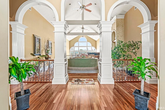 entrance foyer featuring high vaulted ceiling, ceiling fan, wood-type flooring, and decorative columns