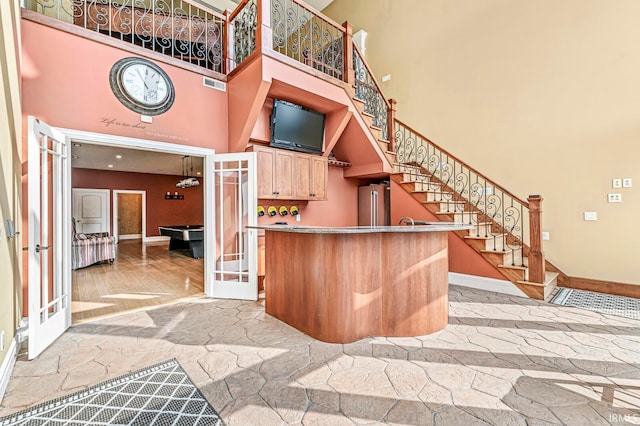 interior space featuring a towering ceiling and hardwood / wood-style floors