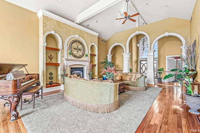 living room featuring high vaulted ceiling, wood-type flooring, ceiling fan, and beamed ceiling