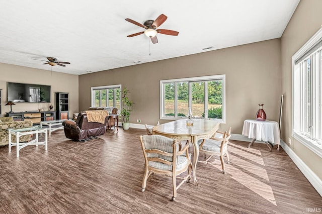 dining space with a healthy amount of sunlight, ceiling fan, and hardwood / wood-style flooring