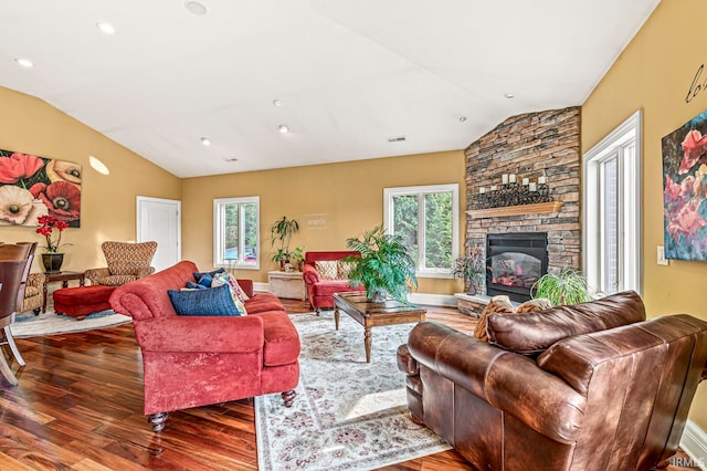 living room featuring a stone fireplace, dark hardwood / wood-style floors, and a healthy amount of sunlight