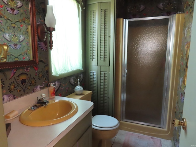 bathroom featuring vanity, toilet, and a shower with door