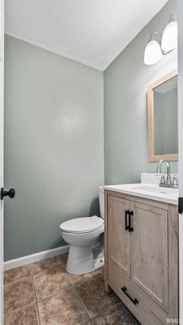 bathroom with tile patterned flooring, toilet, a textured ceiling, and vanity