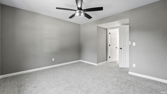 carpeted spare room featuring ceiling fan