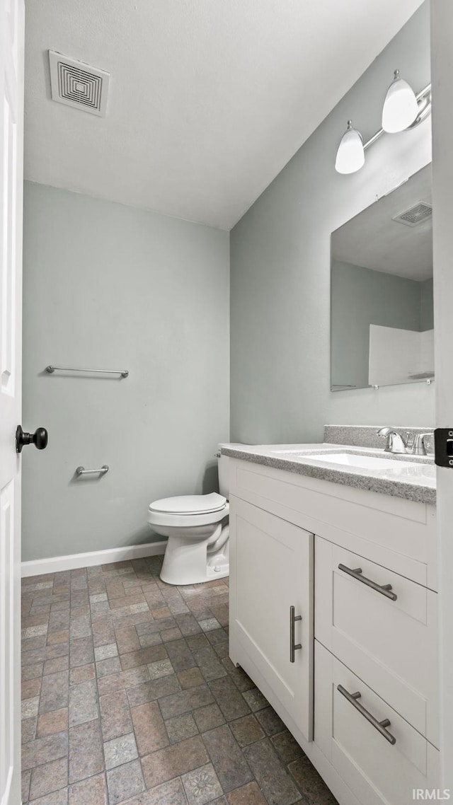 bathroom featuring toilet and vanity