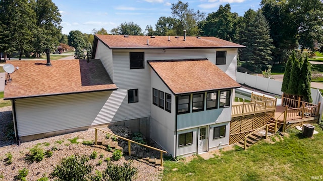 back of house featuring a deck and a lawn