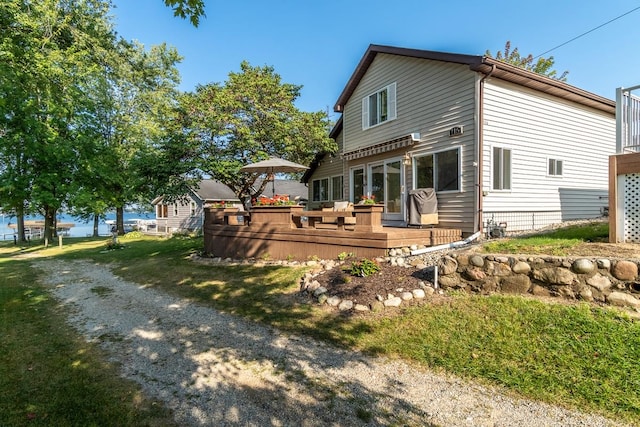 rear view of property with a lawn and a wooden deck