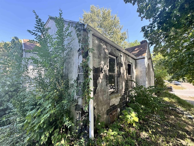 view of side of property with stucco siding and a chimney