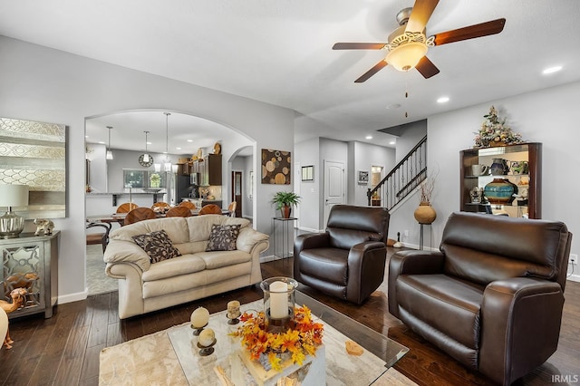 living room featuring ceiling fan and dark hardwood / wood-style floors