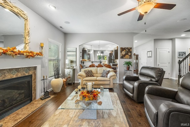 living room with ceiling fan, a fireplace, and dark hardwood / wood-style flooring