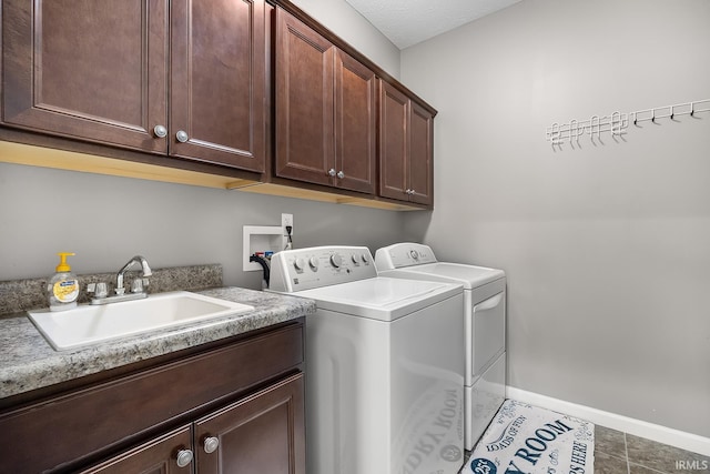 clothes washing area with dark tile patterned floors, sink, cabinets, and separate washer and dryer