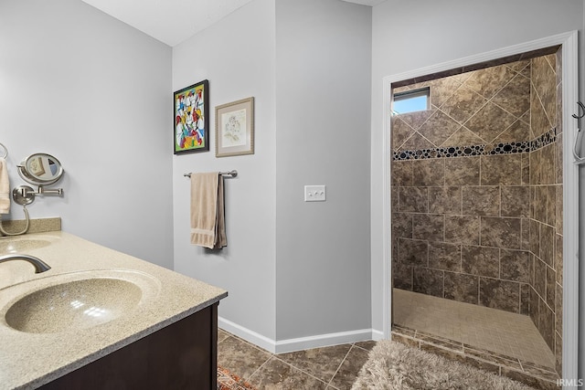 bathroom featuring vanity, a tile shower, and tile patterned floors