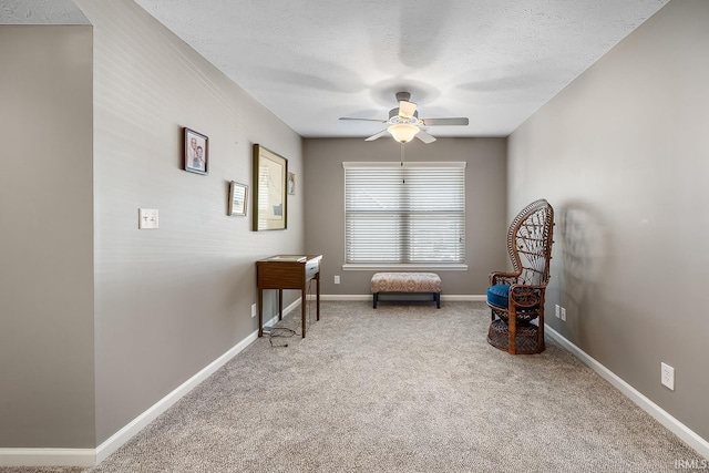 sitting room featuring a textured ceiling, ceiling fan, and carpet