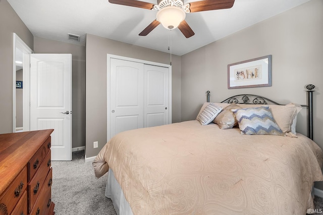 carpeted bedroom with ceiling fan and a closet