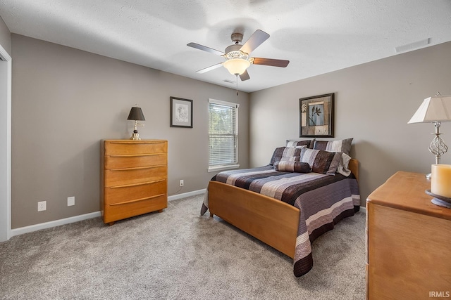 bedroom with a textured ceiling, carpet flooring, and ceiling fan