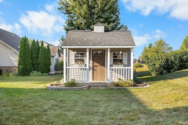 bungalow with an outdoor structure, a porch, and a front lawn