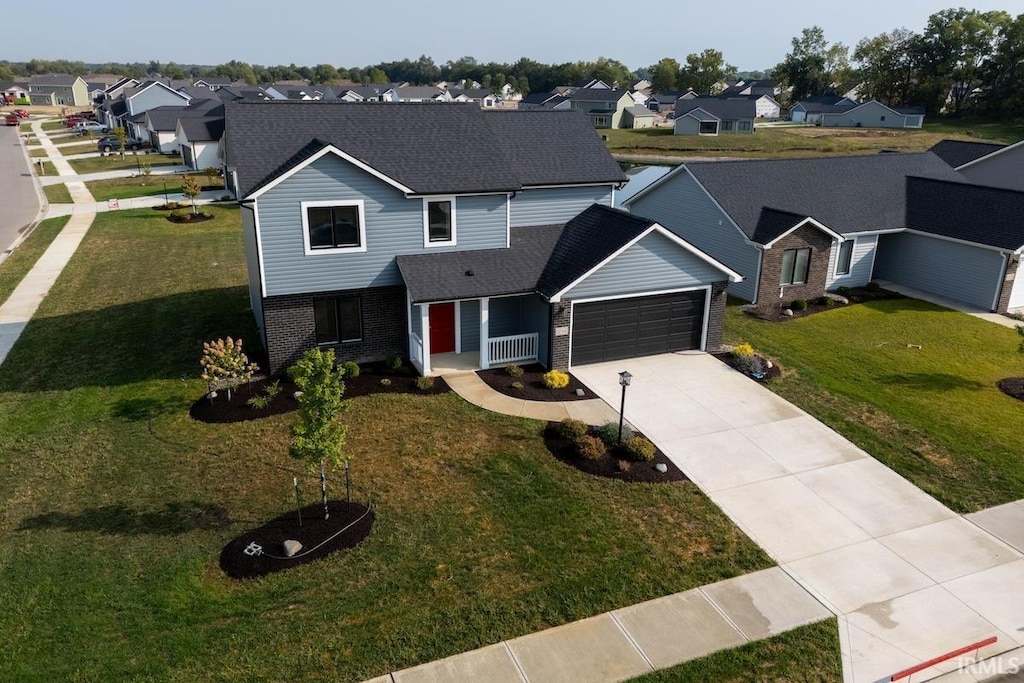traditional home with a garage, a residential view, driveway, and brick siding