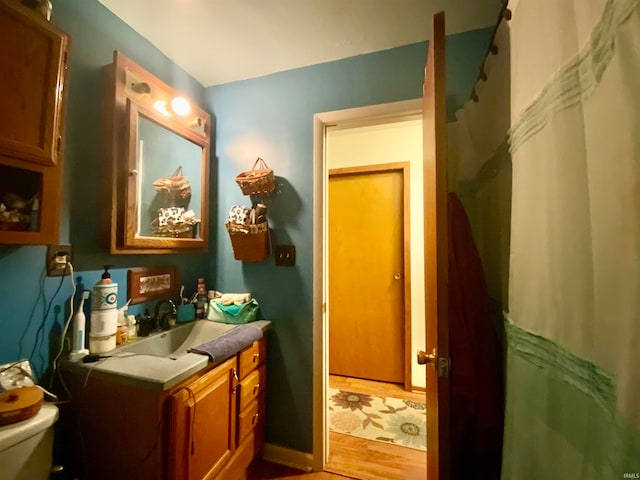 bathroom featuring vanity, toilet, and hardwood / wood-style floors