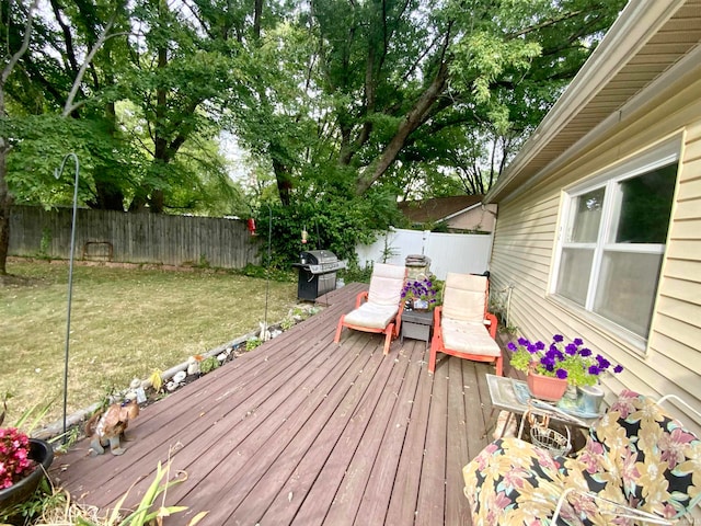 wooden deck with a yard and area for grilling