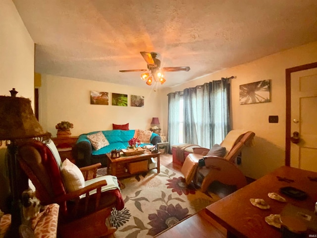 living room with ceiling fan and a textured ceiling