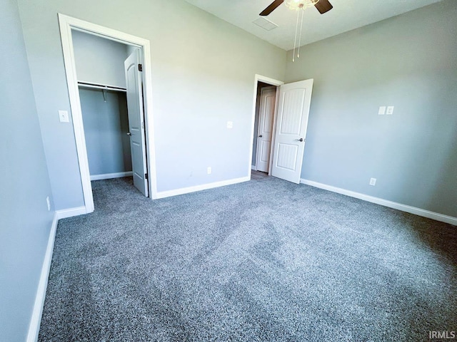 unfurnished bedroom with dark colored carpet, ceiling fan, and a closet