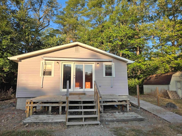 back of house with a storage shed