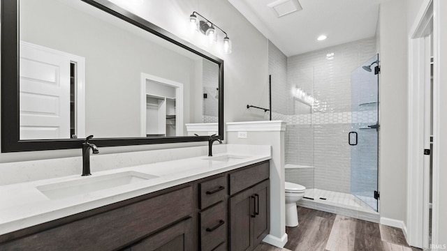 bathroom with vanity, toilet, hardwood / wood-style flooring, and walk in shower