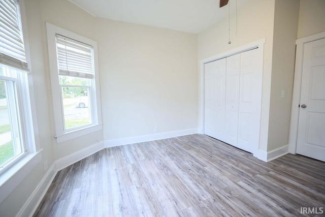 unfurnished bedroom with ceiling fan, a closet, and light hardwood / wood-style floors