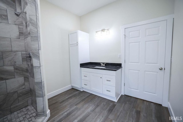 bathroom featuring tiled shower, hardwood / wood-style floors, and vanity