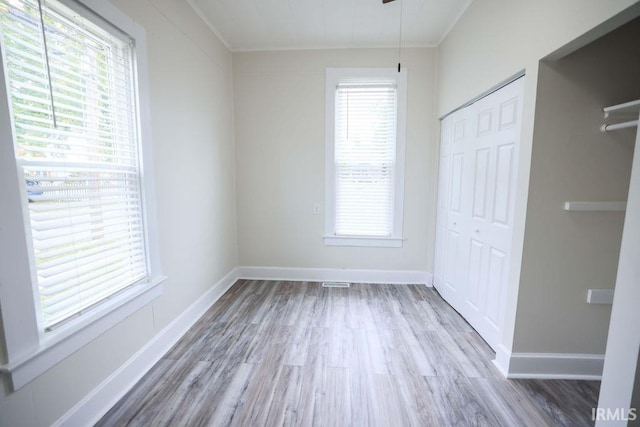 unfurnished bedroom with multiple windows and hardwood / wood-style floors