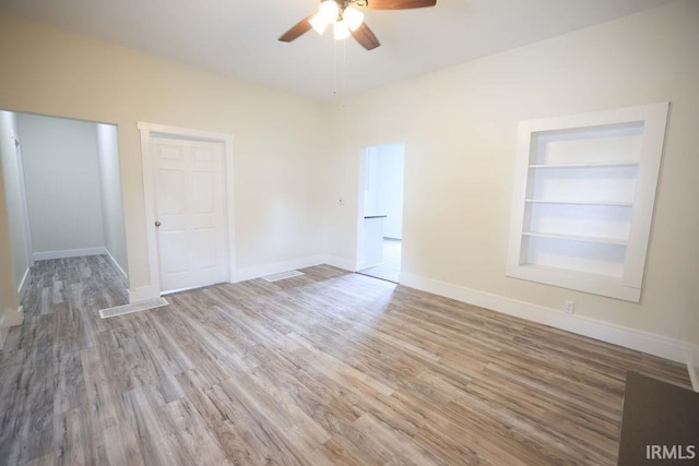 interior space featuring built in features, ceiling fan, and light hardwood / wood-style floors