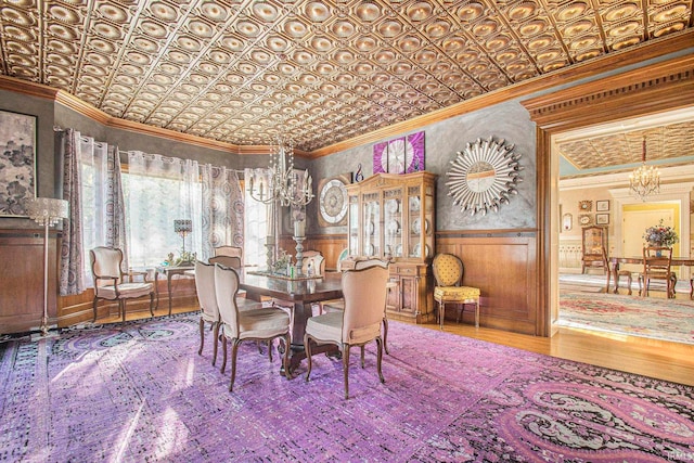 dining area with ornamental molding, hardwood / wood-style flooring, and a notable chandelier