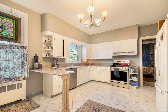 kitchen with decorative light fixtures, appliances with stainless steel finishes, radiator heating unit, and white cabinetry