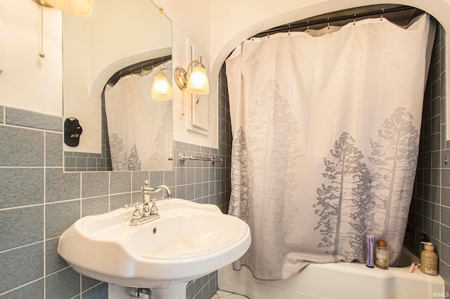 bathroom featuring tile walls, backsplash, sink, and shower / bath combo