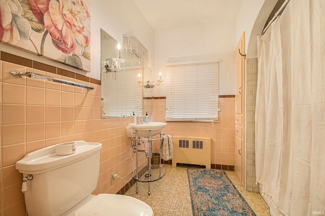 bathroom featuring radiator, walk in shower, tile walls, toilet, and tile patterned floors