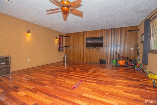 unfurnished living room with a textured ceiling, hardwood / wood-style floors, and ceiling fan