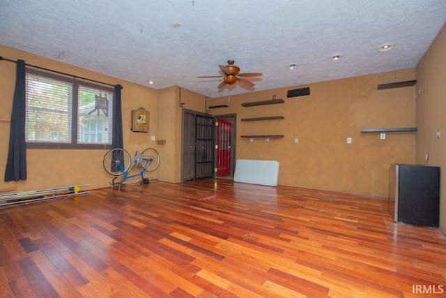 interior space with light wood-type flooring, a textured ceiling, and ceiling fan