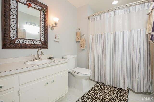 bathroom featuring a shower with shower curtain, vanity, toilet, and tile patterned floors