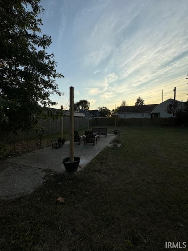 yard at dusk featuring a patio