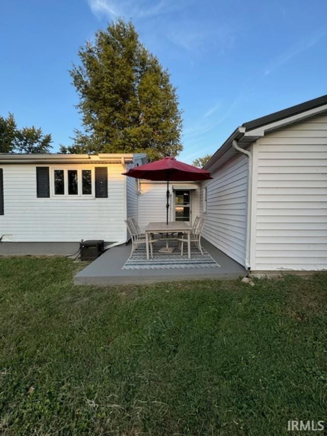 rear view of house with a yard and a patio