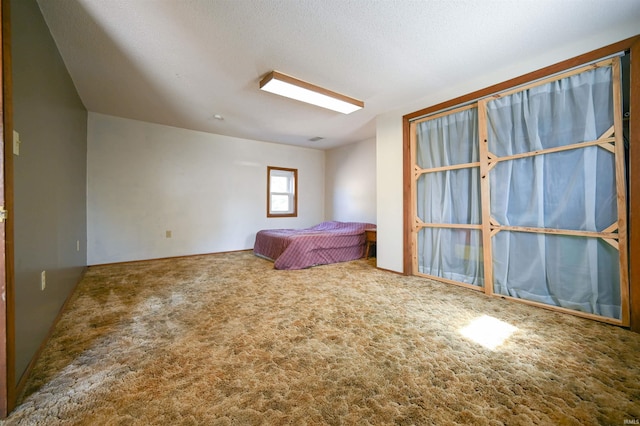 unfurnished bedroom featuring a textured ceiling and carpet