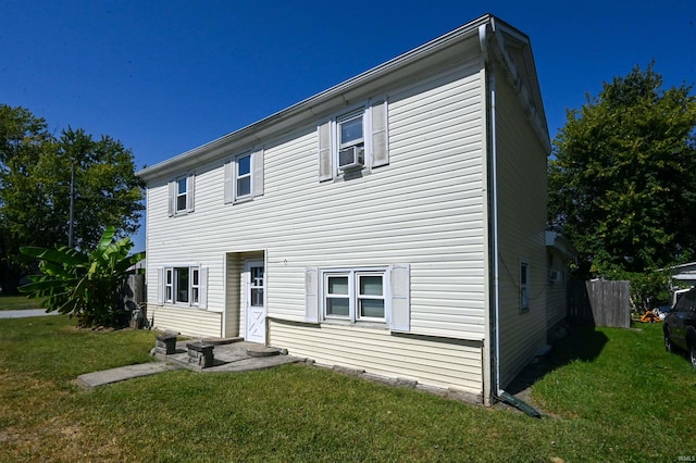 colonial-style house with a front yard and cooling unit