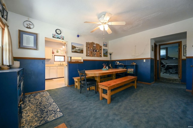 carpeted dining room featuring a textured ceiling, sink, ceiling fan, and a wealth of natural light