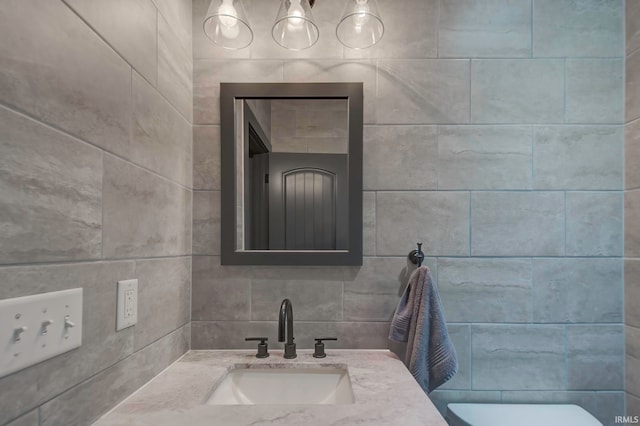 bathroom featuring vanity, tile walls, and toilet